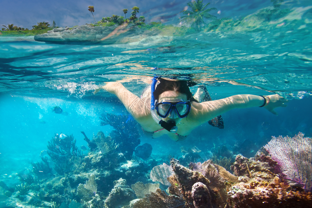 Young women at snorkeling in the tropical water
