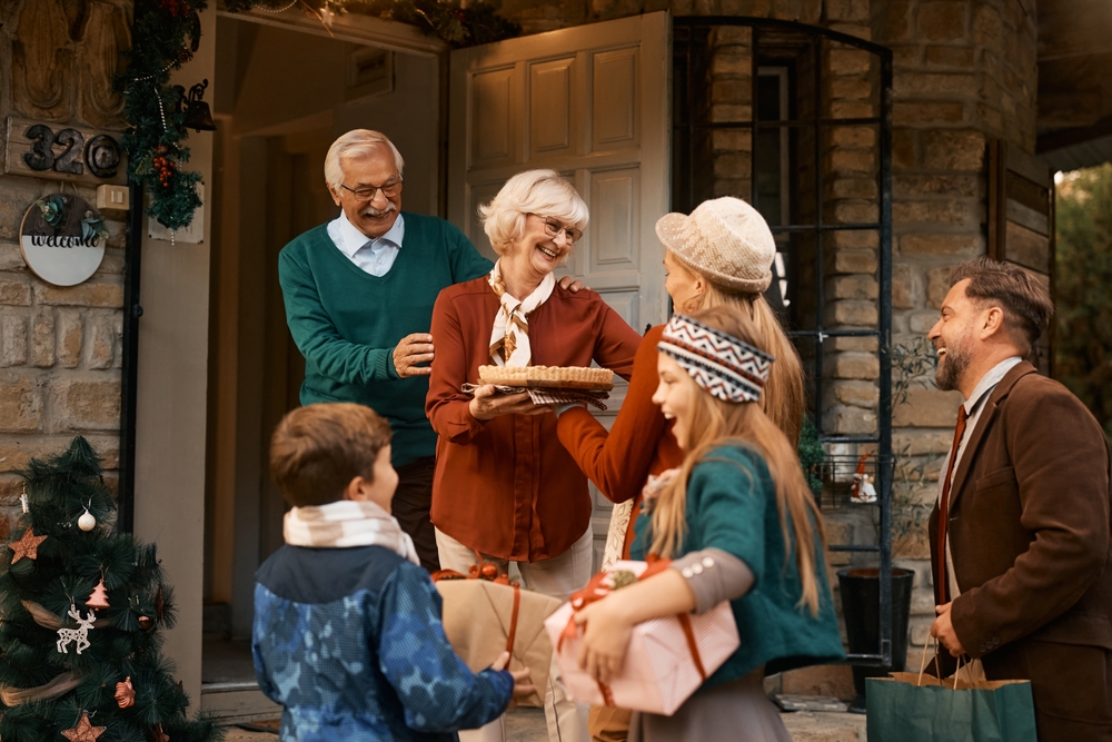 Happy senior couple welcoming their family at doorstep on Thanksgiving.