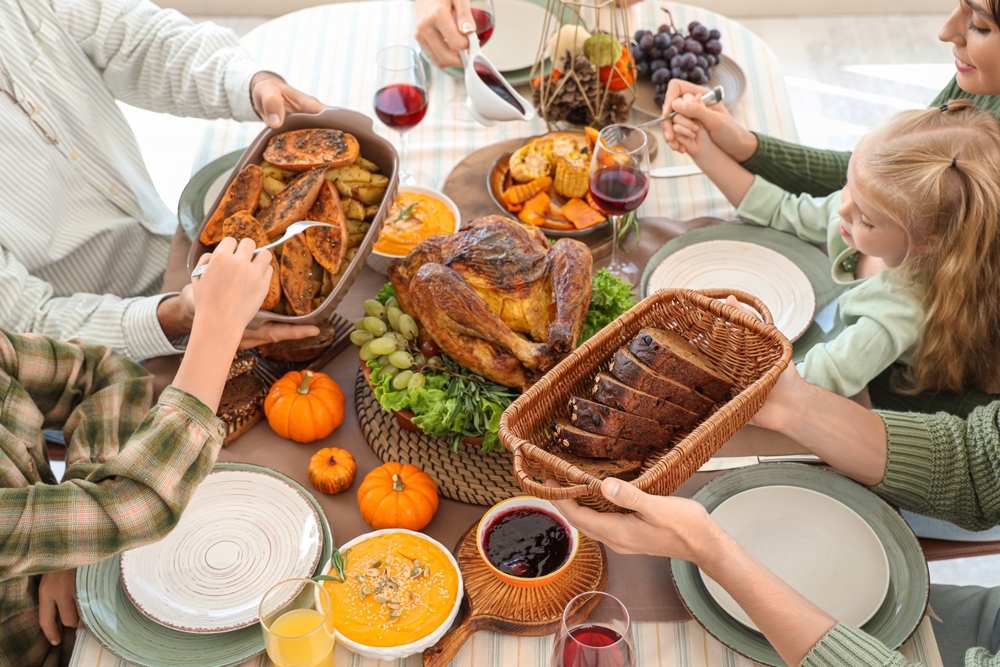 Happy family having dinner at festive table on Thanksgiving Day