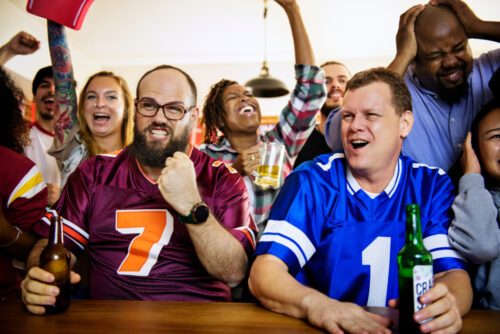 Friends cheering at super bowl party